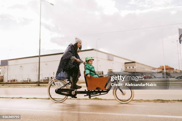 fietstocht van de lading op de regen - family in rain stockfoto's en -beelden