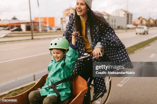 fracht-radtour auf dem regen - child and parent and bike stock-fotos und bilder
