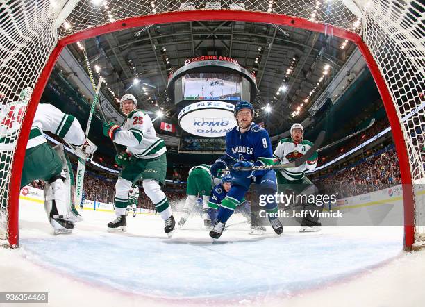 Jonas Brodin and Zach Parise of the Minnesota Wild and Brendan Leipsic of the Vancouver Canucks watch a loose puck during their NHL game at Rogers...