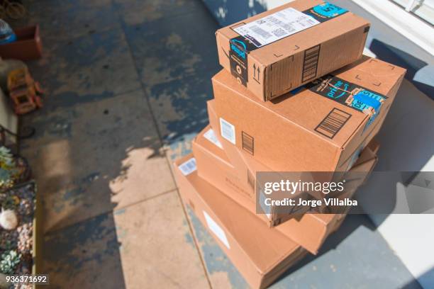 cardboard package delivery at front door - amazon boxes stock pictures, royalty-free photos & images