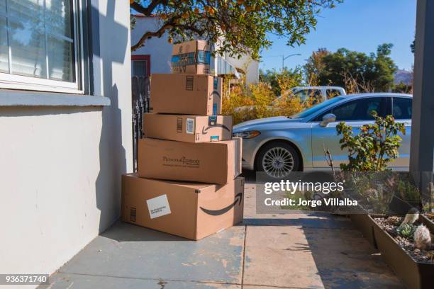 cardboard package delivery at front door - amazon boxes stock pictures, royalty-free photos & images