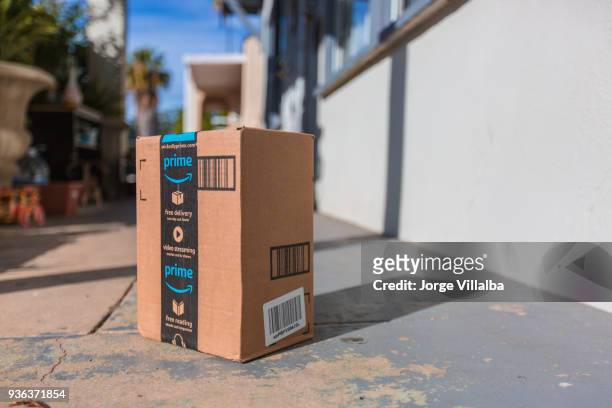 cardboard package delivery at front door - amazon boxes stock pictures, royalty-free photos & images