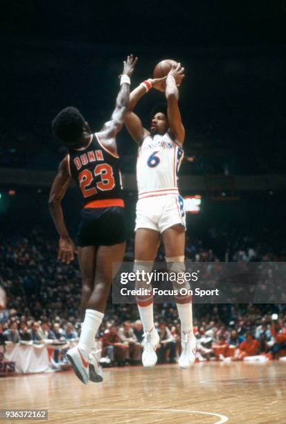 Julius Erving of the Philadelphia 76ers shoots over T.R. Dunn of the Portland Trail Blazers during an NBA basketball game circa 1978 at The Spectrum...