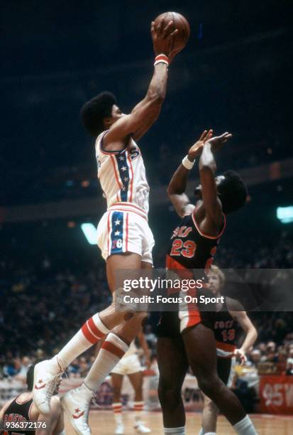 Julius Erving of the Philadelphia 76ers shoots over T.R. Dunn of the Portland Trail Blazers during an NBA basketball game circa 1978 at The Spectrum...