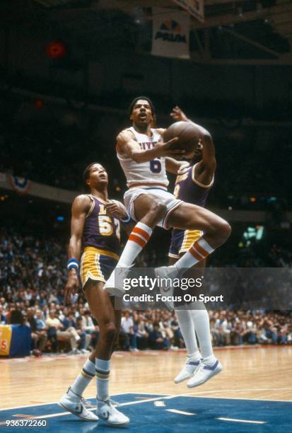 Julius Erving of the Philadelphia 76ers shoots over Jamaal Wilkes of the Los Angeles Lakers during an NBA basketball game circa 1982 at The Spectrum...