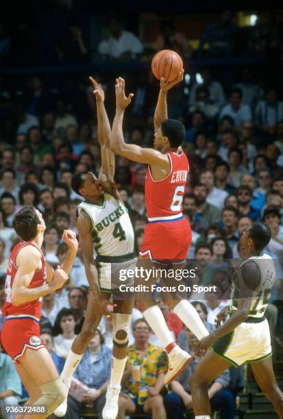 Julius Erving of the Philadelphia 76ers shoots over Sidney Moncrief of the Milwaukee Bucks during an NBA basketball game circa 1986 at the MECCA...