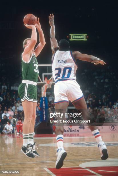 Larry Bird of the Boston Celtics shoots shoots over Bernard King of the Washington Bullets during an NBA basketball game circa 1990 at the Capital...