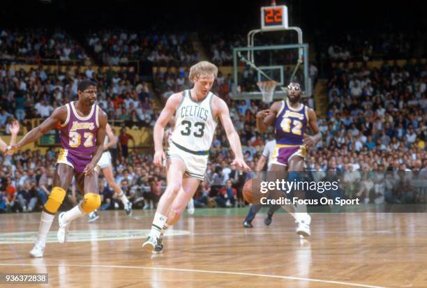 Larry Bird of the Boston Celtics dribbles the ball against the Los Angeles Lakers during an NBA basketball game circa 1985 at the Boston Garden in...