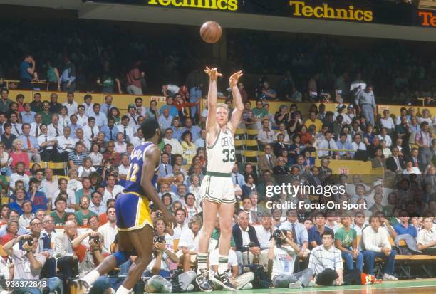 Larry Bird of the Boston Celtics shoots over James Worthy of the Los Angeles Lakers during an NBA basketball game circa 1984 at the Boston Garden in...