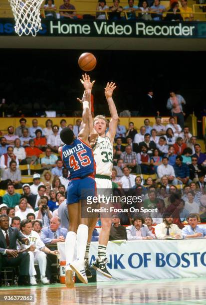 Larry Bird of the Boston Celtics shoots over Adrian Dantley of the Detroit Pistons during an NBA basketball game circa 1987 at the Boston Garden in...