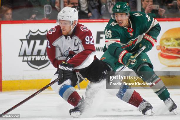 Gabriel Landeskog of the Colorado Avalanche skates with the puck while Jared Spurgeon of the Minnesota Wild defends during the game at the Xcel...