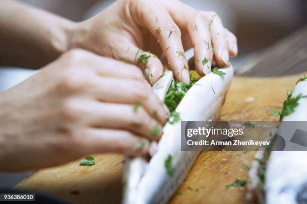 hands of woman chef preparing fish food - ausnehmen stock-fotos und bilder
