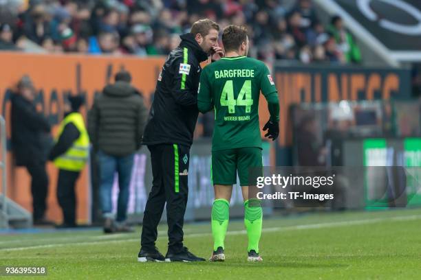 Head coach Florian Kohfeldt of Bremen speaks with Philipp Bargfrede of Bremen during the Bundesliga match between FC Augsburg and SV Werder Bremen at...