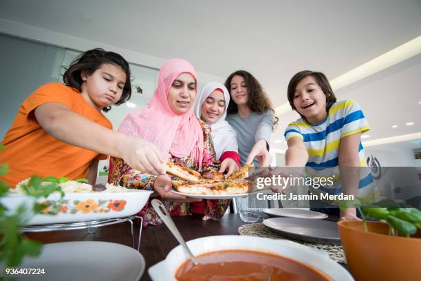 serving iftar for ramadan at home - arab teen photos et images de collection