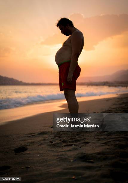 fat man with big stomach - fat guy on beach fotografías e imágenes de stock