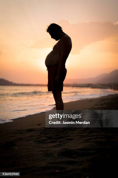 fat man with big stomach - fat guy on beach stockfoto's en -beelden