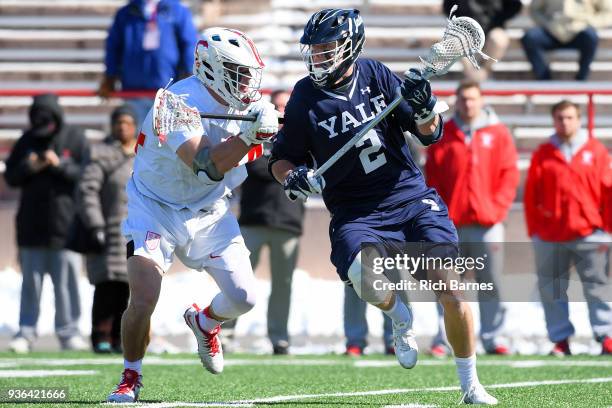 Ben Reeves of the Yale Bulldogs dodges to the goal against the defense of Jake Pulver of the Cornell Big Red during the first half at Schoellkopf...