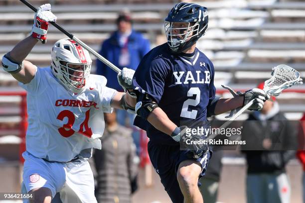 Ben Reeves of the Yale Bulldogs dodges to the goal against the defense of Jake Pulver of the Cornell Big Red during the first half at Schoellkopf...