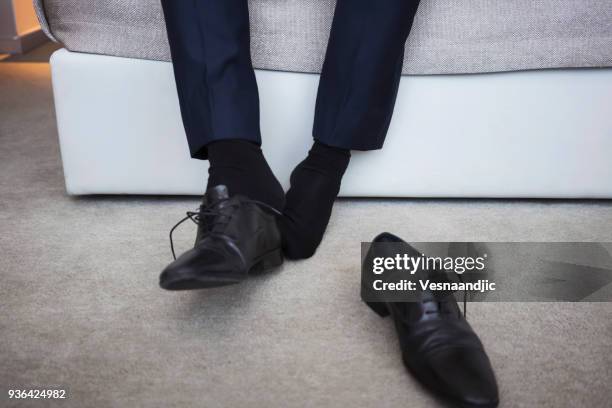 businessman on a business trip at the hotel room - removing shoes stock pictures, royalty-free photos & images