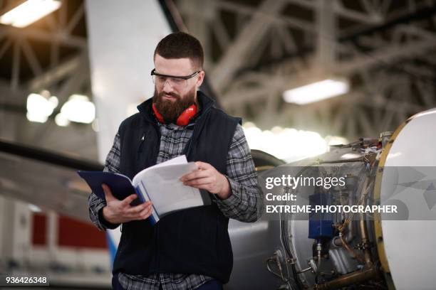 meccanico aeronautico nell'hangar - manuale foto e immagini stock
