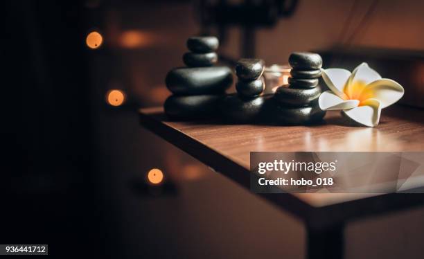 lit candles and black massage stones in zen spa - lastone therapy stock pictures, royalty-free photos & images