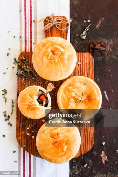 chicken pot pies with carrot and green peas on a wooden table. easter food. rustic style. comfort food. traditional american food for lunch, dinner or summer picnic. - meat pie stockfoto's en -beelden