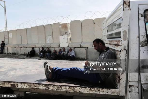 Palestinian truck drivers sit with their lorries near the Kerem Shalom Crossing between the southern Gaza Strip and Israel on March 22 during a...