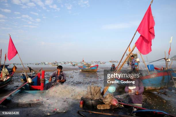 Fishermen preparing a net on the beach. Vung Tau. Vietnam.
