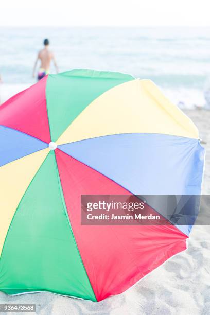 colourful beach umbrella in middle of seaside - zuma beach foto e immagini stock