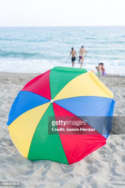 colourful beach umbrella in middle of seaside - zuma beach foto e immagini stock