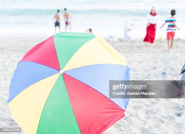 colourful beach umbrella in middle of seaside - zuma beach foto e immagini stock