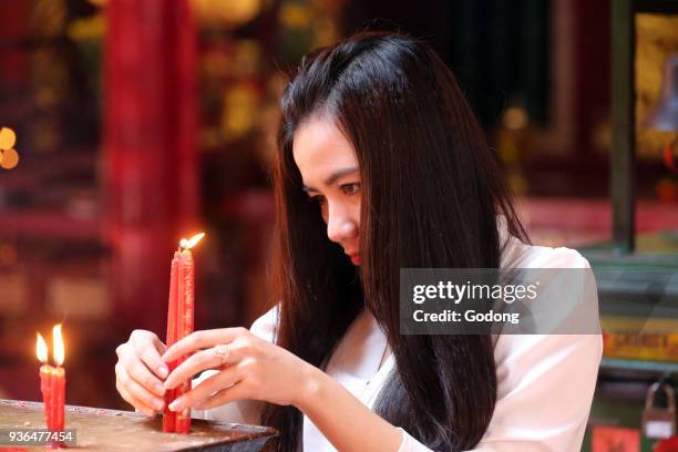 Chua On Lang taoist temple. Buddhist Worshipper. Candles. Ho chi Minh City. Vietnam.