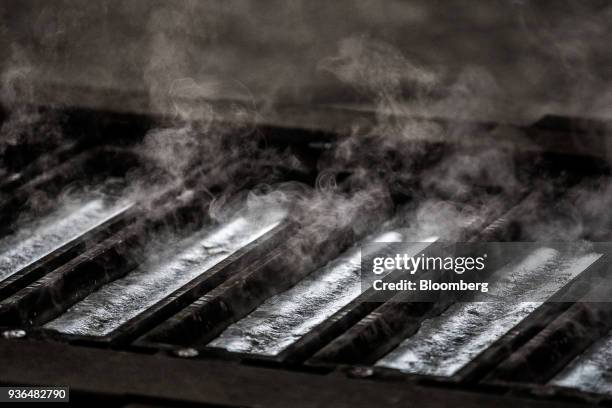 Steam rises from olten aluminum as it cools inside ingot molds at the Alumetal Group Hungary Kft. Aluminium processing plant in Komarom, Hungary on...