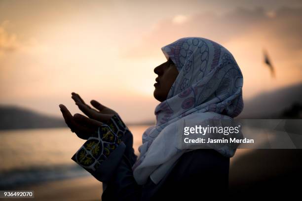 woman at sunset on beach - muslim woman beach stock-fotos und bilder