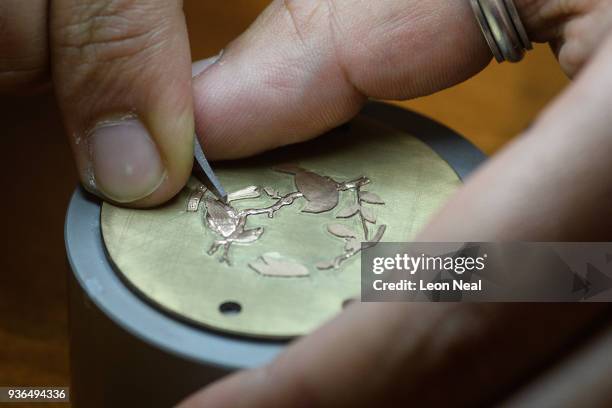 Craftsman continues his detailed hand engraving on a Blancpain timepiece at the Baselworld watch fair on March 22, 2018 in Basel, Switzerland. The...