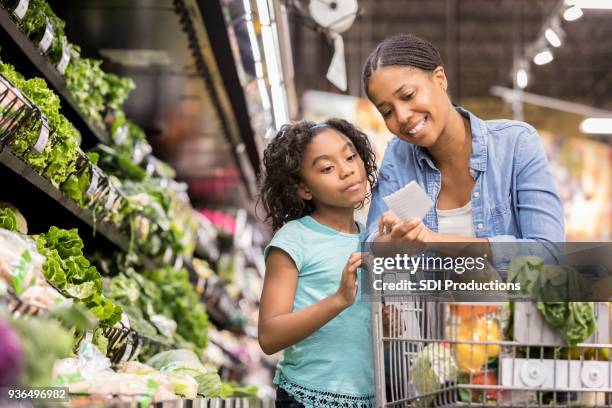 tienda de abarrotes madre e hija junto con lista - supermercado fotografías e imágenes de stock