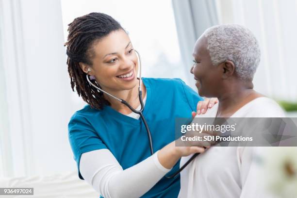 home healthcare nurse checks patient's lungs - nurse listening to patient stock pictures, royalty-free photos & images