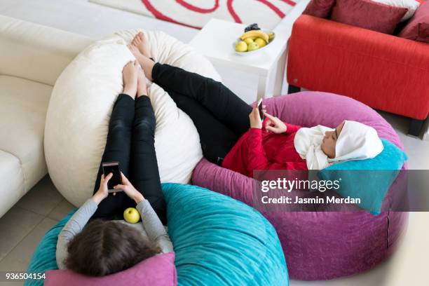 girls having relaxed time on big pillows - arab family in hotel stock-fotos und bilder