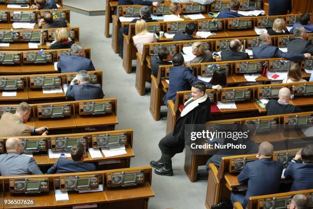 Ukrainian parliamentary deputy Nadiya Savchenko stand in a parliamentary hall as other lawmakers watch the CCTV evidences of her guilt during a...