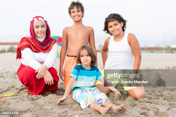 arabian girl on beach with family - day in the life series - fotografias e filmes do acervo