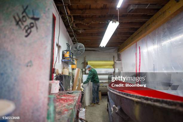 Worker prepares a canoe for its fibreglass shell at the Holy Cow Canoe Co. Production facility in Guelph, Ontario, Canada, on Thursday, March 1,...