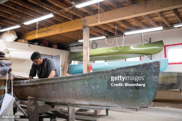 Worker polishes the interior of a canoe mold at the Holy Cow Canoe Co. Production facility in Guelph, Ontario, Canada, on Thursday, March 1, 2018....