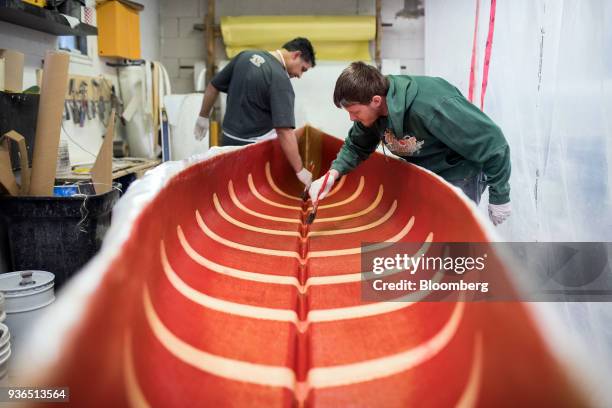 Workers apply fiberclass resin to a canoe at the Holy Cow Canoe Co. Production facility in Guelph, Ontario, Canada, on Thursday, March 1, 2018....