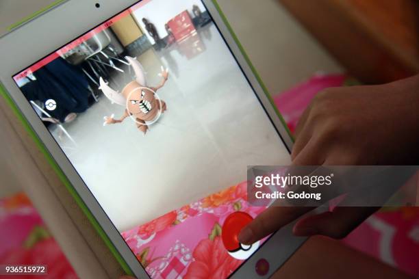 Girl playing with her tablet during a Pokemon Go gaming. Ho Chi Minh City. Vietnam.
