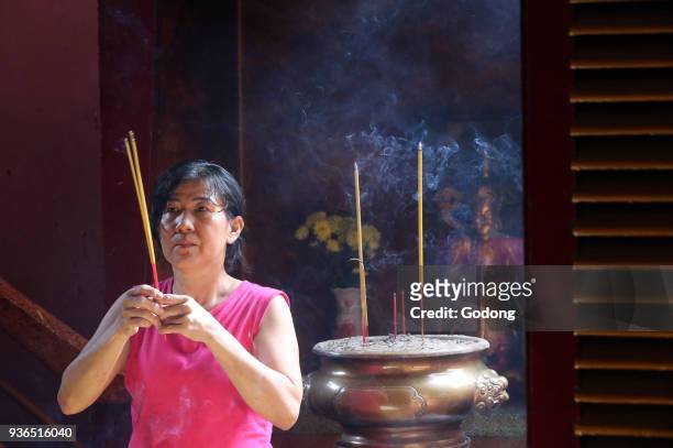 Khanh Van Nam Vien Taoist pagoda. Buddhist Worshipper. Burning incense sticks. Ho chi Minh City. Vietnam.