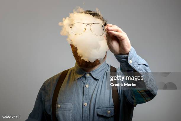 retrato de un hombre que está fumando un cigarrillo de e - humo de cigarrillo electrónico fotografías e imágenes de stock