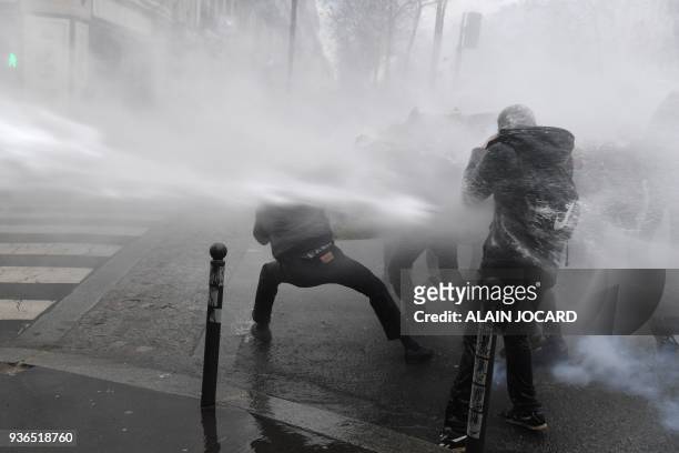 Police use water canon against demonstrators during a protest against French government's string of reforms, on March 22, 2018 in Paris. Seven trade...