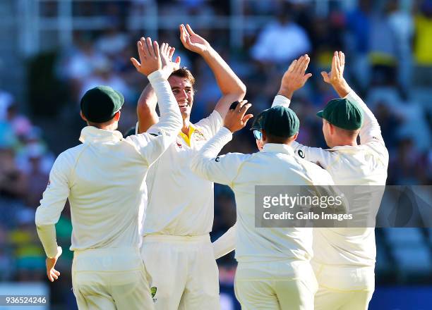 Pat Cummins and team mates of Australia celebrate the wicket of Quinton de Kock of South Africa during day 1 of the 3rd Sunfoil Test match between...