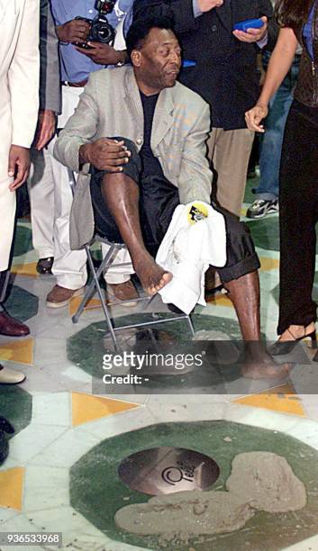Edson Arantes do Nascimento, known as Pele, steps in fresh cement to leave his mark on the path of fame at the Maracana stage 16 June 2000 in Rio de...