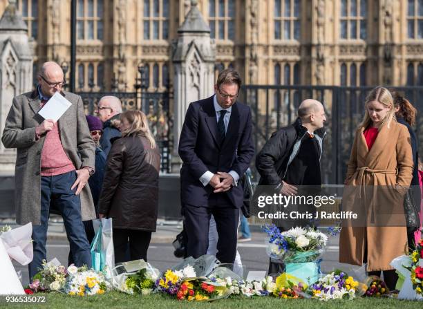 Tobias Ellwood looks at floral tributes in Parliament Square on the first anniversary of the Westminster Bridge terror attack on March 22, 2018 in...